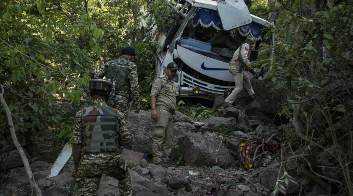Security men inspect a bus that fell into a deep gorge on Sunday after it was fired at by suspected militants in Reasi district, Jammu and Kashmir, on 10 June 2024. AP