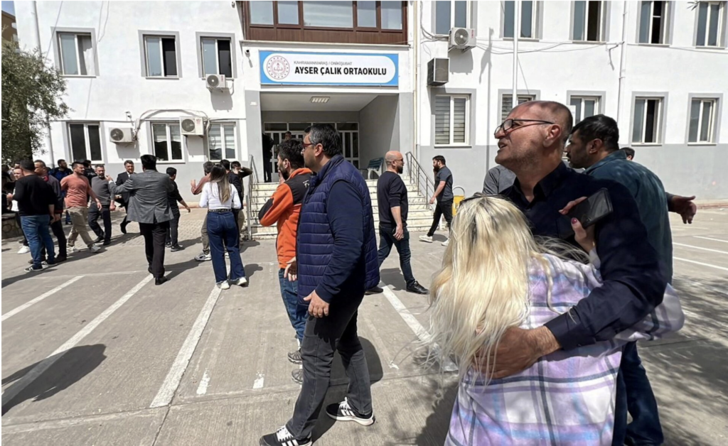 People wait in front of the school building after a deadly shooting, in the southeastern province of Kahramanmaras, Turkey, April 15, 2026. Picture taken with a mobile phone. IHA (Ihlas News Agency) via REUTERS