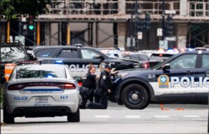 Montreal police take cover during the shooting. Photograph: Christopher Katsarov/The Canadian Press/AP
