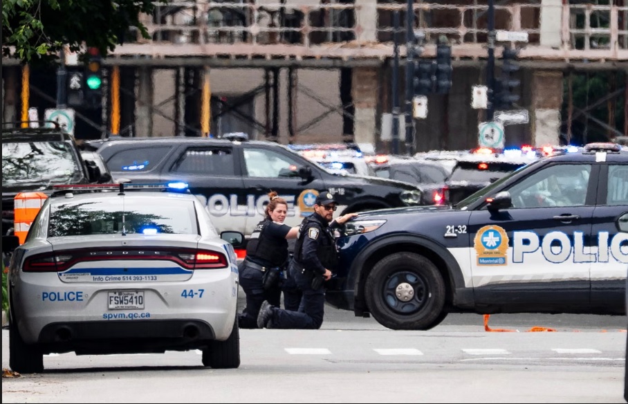Montreal police take cover during the shooting. Photograph: Christopher Katsarov/The Canadian Press/AP
